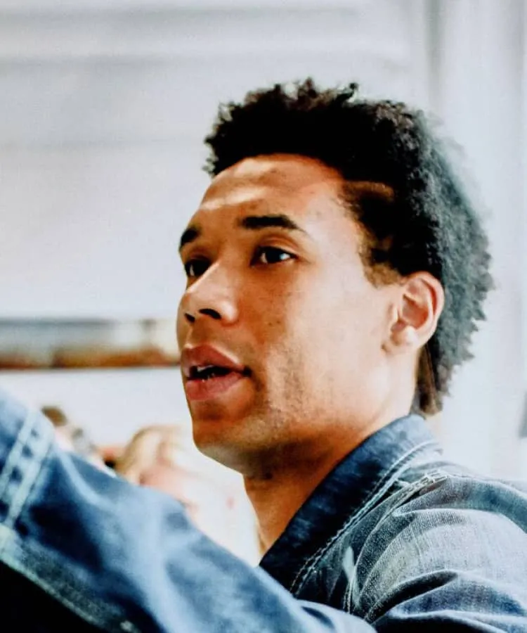 A man in a denim jacket taking something from a shelf