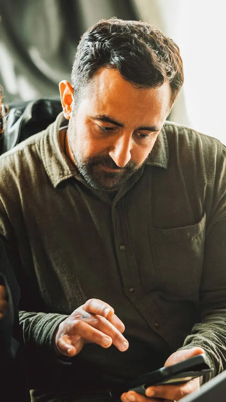 Two men sit at the same desk analyzing some work