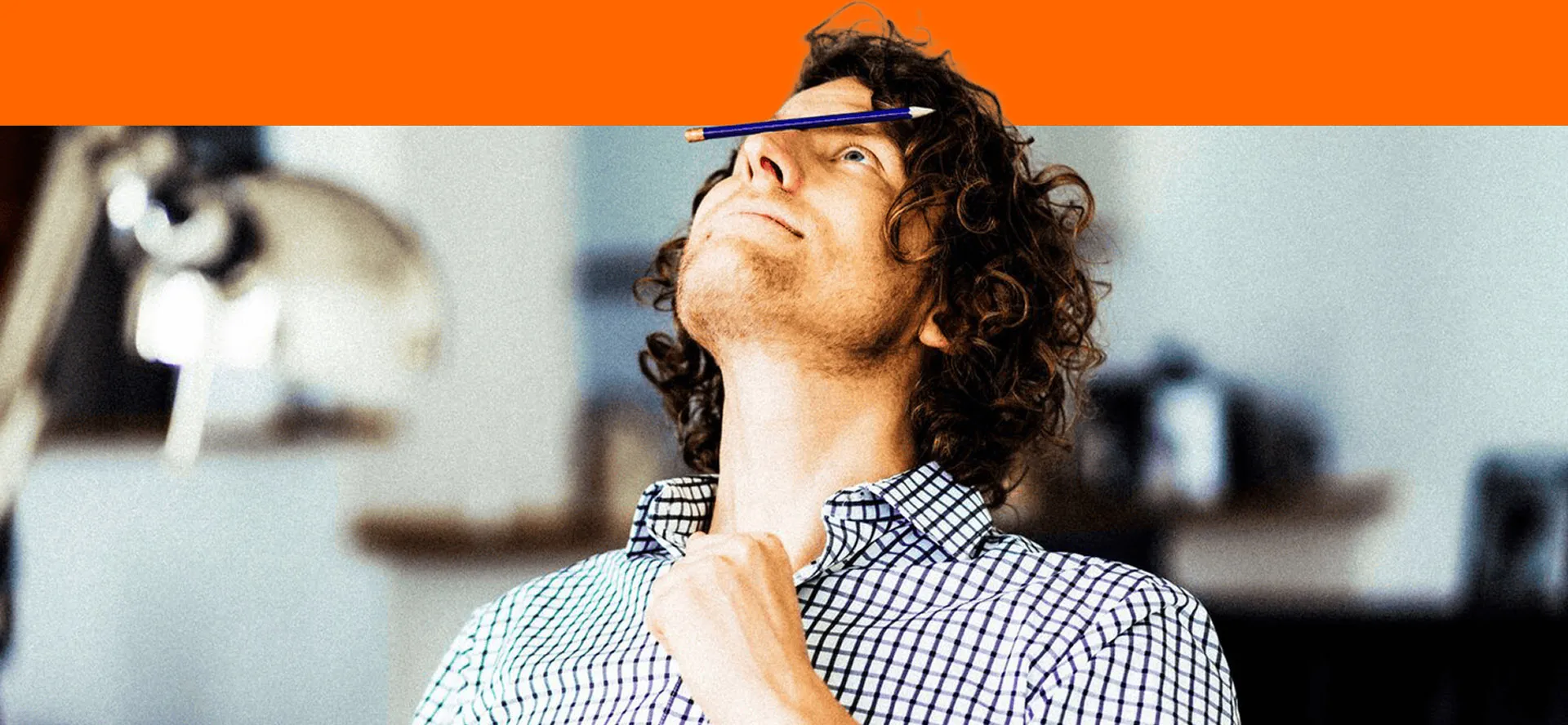 A young man balancing a pencil on his nose