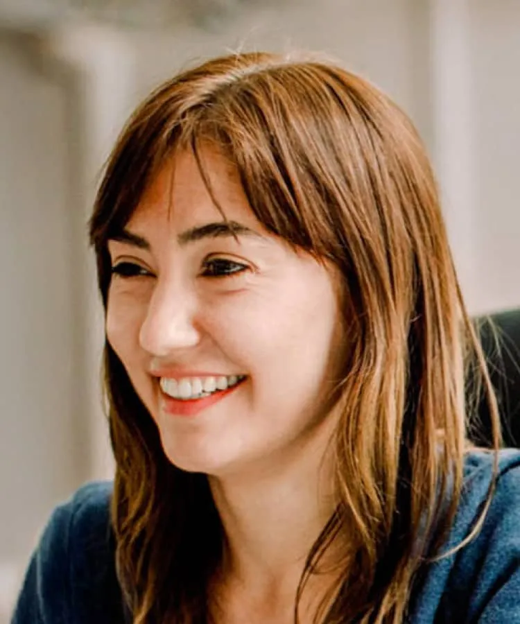 A woman wearing blue sitting at an office chair